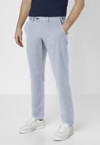 Light blue trousers made of cotton, featuring side pockets and a straight fit, paired with white sneakers for a casual look.