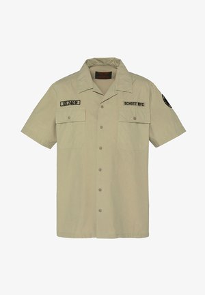 Beige kortærmet skjorte med knapper, to brystlommer, "US.740 N" patch på venstre bryst, "SCHOTT NYC" patch på højre bryst og emblem på ærmet.