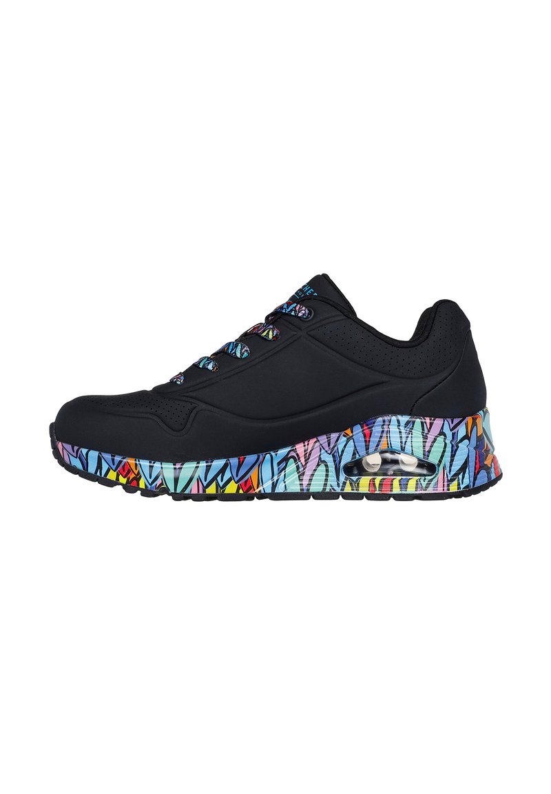 Zapatilla negra con parte superior texturizada, suela de colores con patrones que presentan tonos de azul, rosa y amarillo, y cuello acolchado para mayor comodidad.