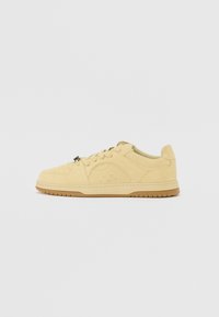 Sneakers in suede giallo chiaro, con punta arrotondata, lacci frontali, dettagli perforati e una suola in gomma per una migliore trazione.