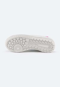 Suela de un zapato de goma blanca con patrones de tracción circulares y rectangulares, con un acento rosa y borde texturizado para mayor agarre.