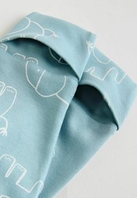 Cotton socks in light blue with a white pattern of bears. Features include a rolled cuff and a soft, textured finish.