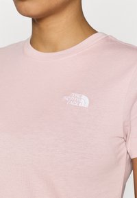 Ροζ βαμβακερό t-shirt με στρογγυλή λαιμόκοψη και κοντά μανίκια, με λευκό κεντημένο λογότυπο στην αριστερή πλευρά του στήθους.