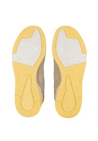 Soli di sneaker in suede beige con suole in gomma gialla, caratterizzati da modelli di grip testurizzati e branding in rilievo.