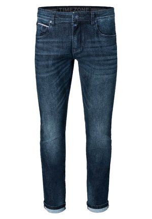 Dark blue denim jeans with a slim fit, five pockets, rolled cuffs, and subtle fading on the legs. Features a button and zipper closure.