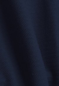 Tessuto di velluto blu navy con una texture a righe, caratterizzato da strisce in rilievo. Il materiale appare morbido e intrecciato.