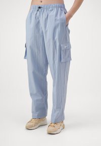 Světle modré cargo kalhoty s elastickým pasem, dvěma bočními kapsami a cargo kapsou na pravé noze. Vyrobeno z texturované látky.