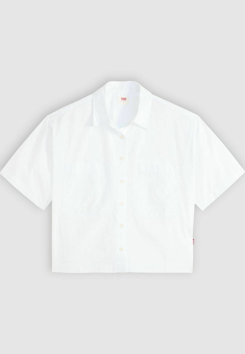 Camicia bianca a maniche corte con colletto, due tasche sul petto e orlo dritto. Realizzata in tessuto di cotone leggero. Dettaglio etichetta rossa.
