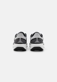 Graue und schwarze Sportschuhe mit Obermaterial aus Mesh, strukturierten Akzenten und ausgeprägter Gummisohle für Traktion. Enthält Gore-Tex-Branding.