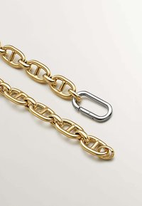 Cadena de metal dorado con eslabones ovalados y un clip de mosquetón plateado, con un acabado suave y brillante y un diseño uniforme.