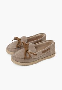 Mocasines de ante beige con una textura suave, cuentan con un cordón de cuerda marrón y una suela de yute trenzado, diseñados para la comodidad y el uso diario.