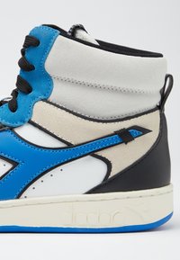 Sneaker alta con blocchi di colore blu, bianco, beige e nero. Realizzata in pelle e suede, con chiusura a lacci e dettaglio del logo.