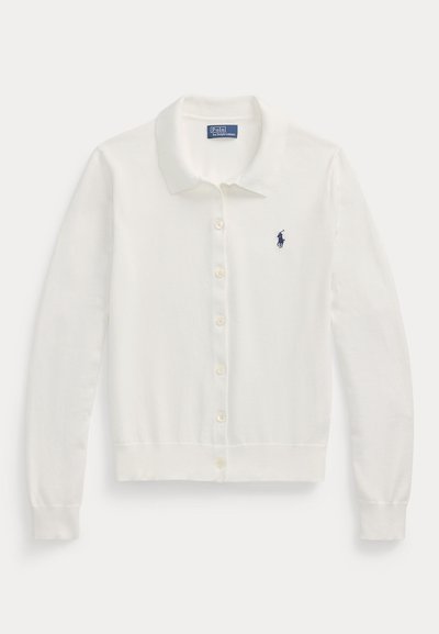 Beli cardigan s polo ovratnikom, z gumbi spredaj, dolgimi rokavi in majhnim mornarsko modrim logotipom na prsih. Mehka pletena tekstura.