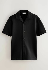 Black short-sleeve shirt made of ribbed fabric with a collar. Features a button front and a relaxed fit. Textured surface for visual interest.