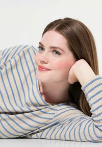 Beige Langarmshirt mit blauen horizontalen Streifen auf einer entspannten Figur, mit einem runden Halsauschnitt und weichem Stoff auf einem hellen Hintergrund.