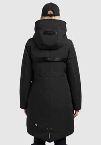 Juodas izoliuotas parkas su kepure, turi logotipo juostą liemens srityje, skeltą apačią ir tekstūruotą audinį. Minimalistinis dizainas, be matomų akcentų.