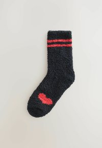 Sort fuzzy sok med røde striber øverst og en lille rød hjerteaccent på siden. Blød tekstur og tykk design til varme.