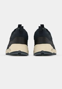 Tumed sinine sportlikud kingad tekstuurse pealsega, kontrastse kreemika keskosa ja tagumiste tõmmetäppidega. Omavad kummist tallat, mis tagab haarde ja paindlikkuse.