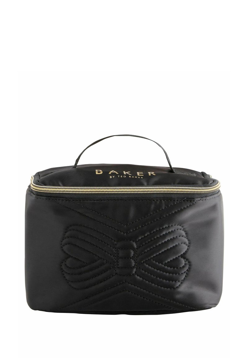 Borsa cosmetica nera trapuntata con manico superiore, zip dorata e design a forma di fiocco in rilievo; presenta il nome del marchio "BAKER" in oro sul davanti.