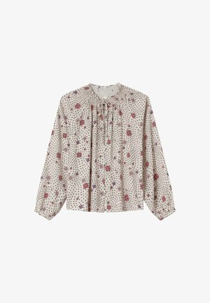 Blouse à motif floral avec des manches longues, encolure froncée et fond beige clair. Présente des fleurs rouges et violettes ainsi qu'un tissu texturé.