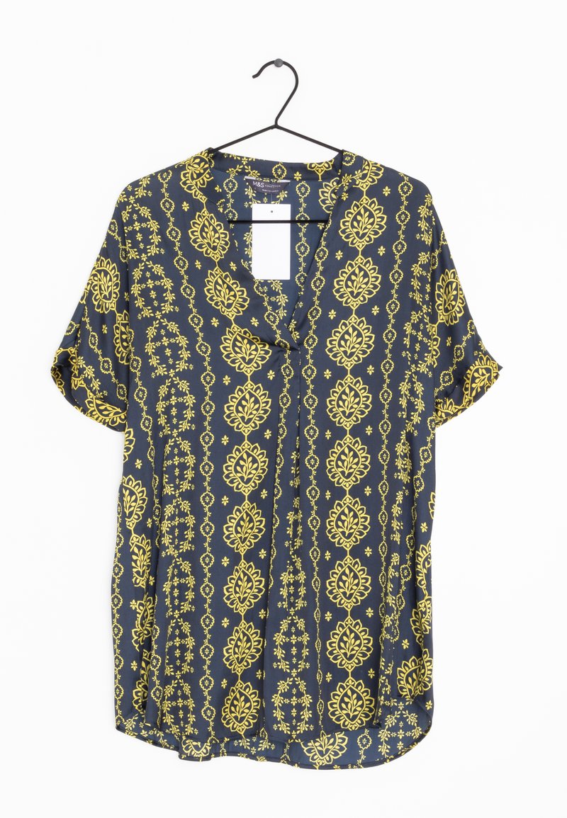 Blouse à manches courtes en tissu bleu foncé avec des motifs floraux et géométriques jaunes, à coupe ample et avec un col à boutons.
