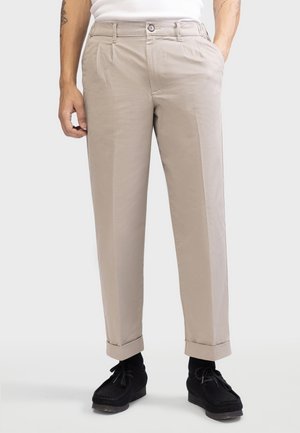 Beige trousers with a straight-leg design, pleated front, and rolled cuffs. Made of lightweight fabric, paired with black shoes.