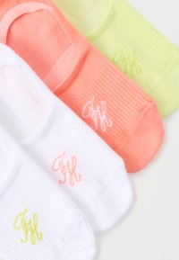 Τέσσερα κάλτσες χωρίς εμφάνιση σε λευκό, ροδακινί και ανοιχτό κίτρινο, καθεμία με ένα μικρό κεντητό λογότυπο κοντά στην περιοχή των δαχτύλων.