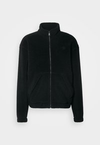 Chaqueta de forro polar negra con cuello alto, cremallera frontal, dos grandes bolsillos laterales y puños acanalados. Textura suave con un corte relajado.