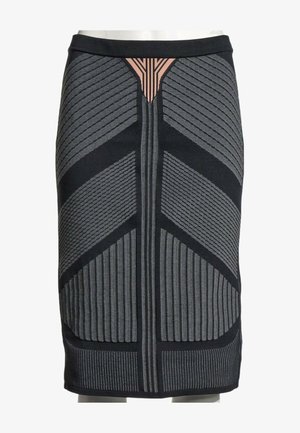 Jupe noire longueur genou avec motifs géométriques gris et rayures verticales, dotée d'une ceinture fine et d'un petit détail triangle pêche près du haut centre.