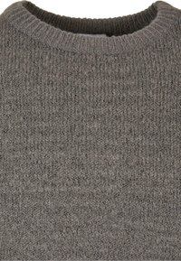 Pull gris en maille avec un col rond, présentant un motif texturé en côtes sur l'ensemble. Le tissu semble doux et chaud.