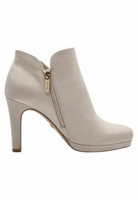 Beige nubukkengät nilkkurit korkealla korolla, sivuvetoketjuyksityiskohdalla ja alustalla. Sileä pinta ja saumatonta muotoilua.