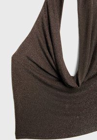 Braunes ärmelloses Oberteil aus strukturiertem Stoff mit silbernen Punkten, das eine drapierte Ausschnittlinie und weiches, fließendes Material aufweist.