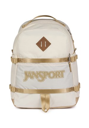 Sac à dos JanSport beige avec deux sangles horizontales, une poignée de transport supérieure, une poche avant zippée et un patch marron en forme de losange.