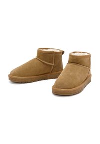Braune Wildleder-Stiefeletten mit abgerundetem Zeh, weichem Fleece-Futter und flachen Gummisohlen. Verfügt über eine äußere Naht und ein minimalistisches Design.