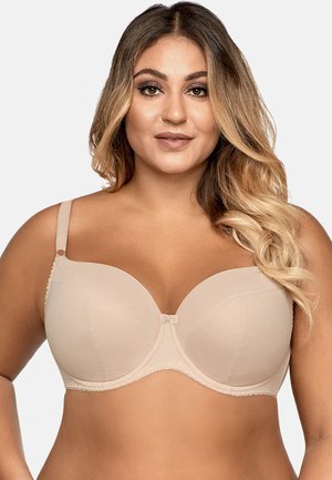 Reggiseno imbottito beige con ferretto, rifinito in pizzo a onde, tessuto liscio e un fiocco decorativo al centro. Spalline regolabili.
