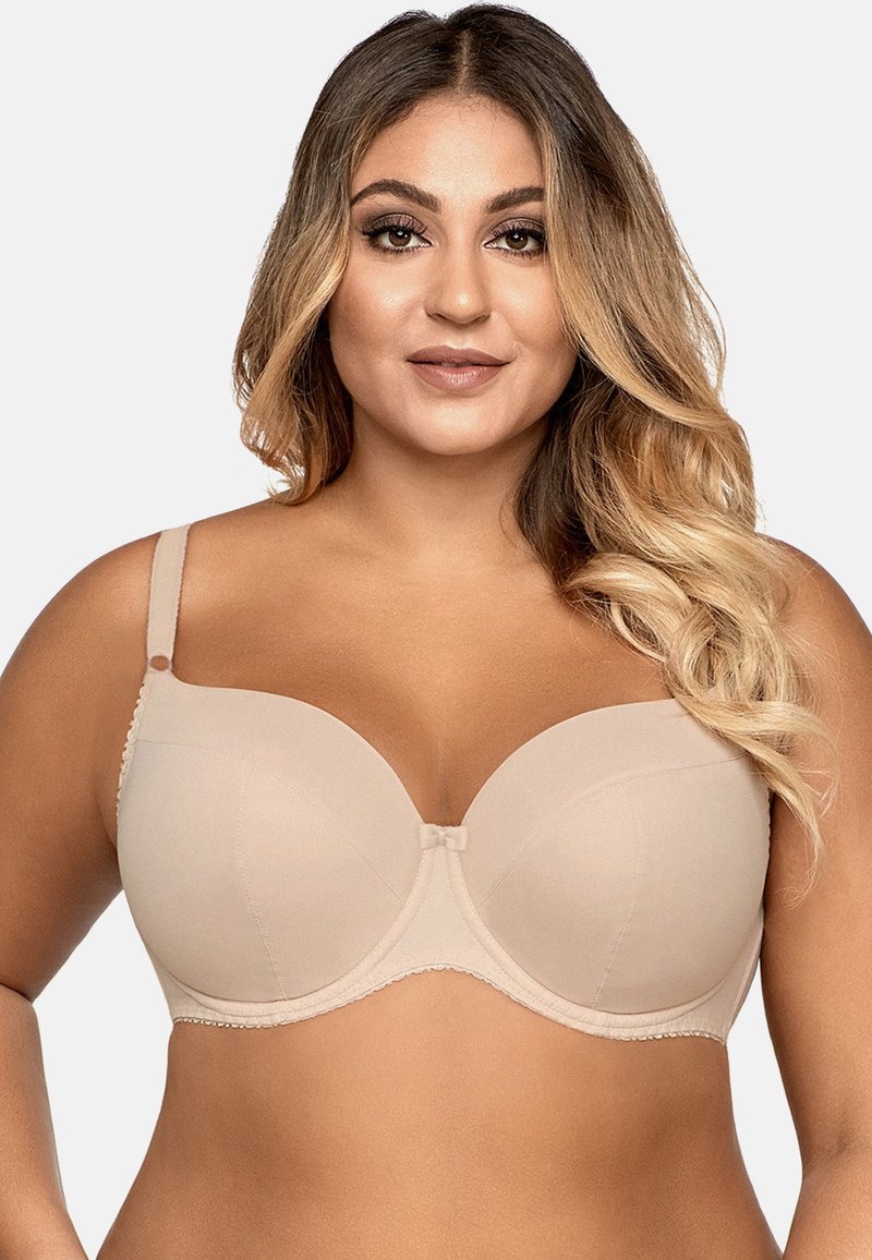 Soutien-gorge en beige avec armatures, rembourré, orné d'une délicate dentelle festonnée, tissu lisse, et un nœud décoratif au centre. Bretelles ajustables.