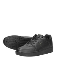 Zapatillas negras de cuero con textura suave. Sus características incluyen lados perforados, cordones planos y una suela de goma con un patrón.