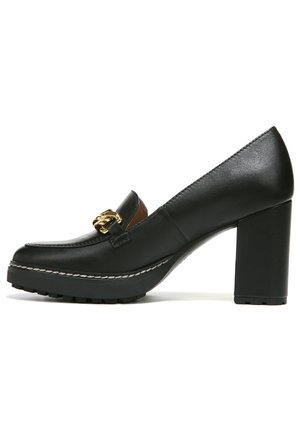 Mocassins à talons en cuir noir avec un talon bloc, ornés d'une chaîne dorée sur le devant et d'une semelle texturée.