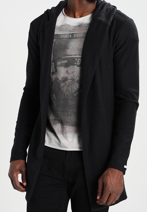 Cardigan noir à capuche avec des manches longues, design à ouverture frontale et texture douce, porté par-dessus un t-shirt graphique avec un imprimé en monochrome.