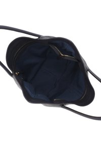 Black leather tote bag interior with navy fabric lining, featuring two zippered pockets and a spacious main compartment.