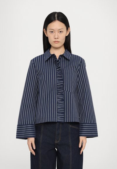 Navy striped button-up shirt with a ruffled front, chest pocket, and wide sleeves. Made from fabric with a smooth texture.