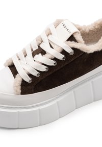 Sneaker in suede marrone con suola in gomma bianca, fodera morbida color crema e lacci bianchi. Presenta occhielli in argento e un'etichetta con il marchio sulla linguetta.