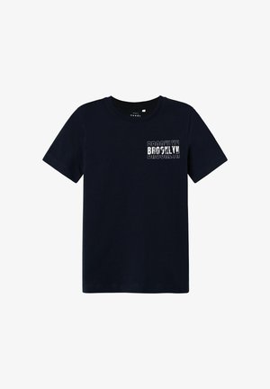Camiseta de algodón azul marino con cuello redondo y mangas cortas, con un gráfico blanco de "BROOKLYN" en la parte superior izquierda.