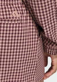 Sukienka w kratkę w kolorze bordowym i jasnoróżowym. Posiada boczną kieszeń i elastyczne mankiety. Wykonana z miękkiej bawełny.