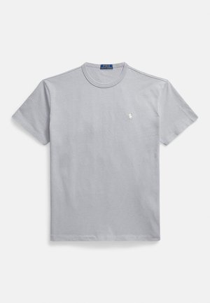 Pilkas medvilninis marškinėlis su apvalia iškirpte, trumpomis rankovėmis ir mažu baltu logotipu kairėje krūtinės pusėje. Lygus audinys ir laisvas siluetas.