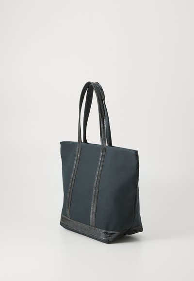 Sac fourre-tout en tissu gris foncé avec des accents en cuir noir, doté de deux longues poignées et d'une forme structurée. Texture mate avec une bordure brillante.