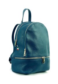Tijgerleder rugzak in teal met een gestructureerde afwerking, dubbele ritssloten, en hardware in zilvertint. Voorzien van een klein Italiaans vlaggetje als bedel.