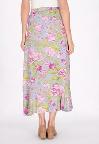 Fustă maxi florală cu un fundal albastru deschis, decorat cu modele florale roz și verzi, talie elastică și tiv cu volane. Asortată cu tocuri blocate bej.