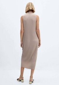 Vestido midi sin mangas de color marrón claro, con costuras acanaladas y una silueta ajustada. La tela tiene una textura suave y el diseño presenta un escote alto.