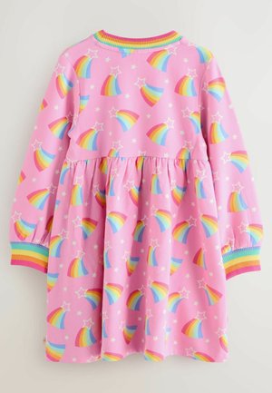 Lyserød kjole lavet af blødt stof med et mønster af farverige regnbuer og stjerner. Volangkant og elastiske manchetter med regnbue-striber.